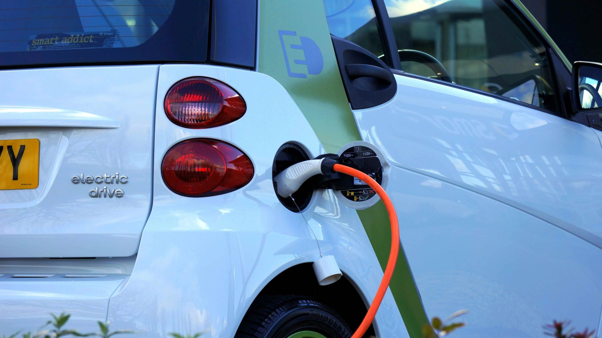 Dlaczego system kontroli wewnętrznej jest tak ważny w przypadku taksonomii ESG? Ładowanie białego samochodu elektrycznego na stacji