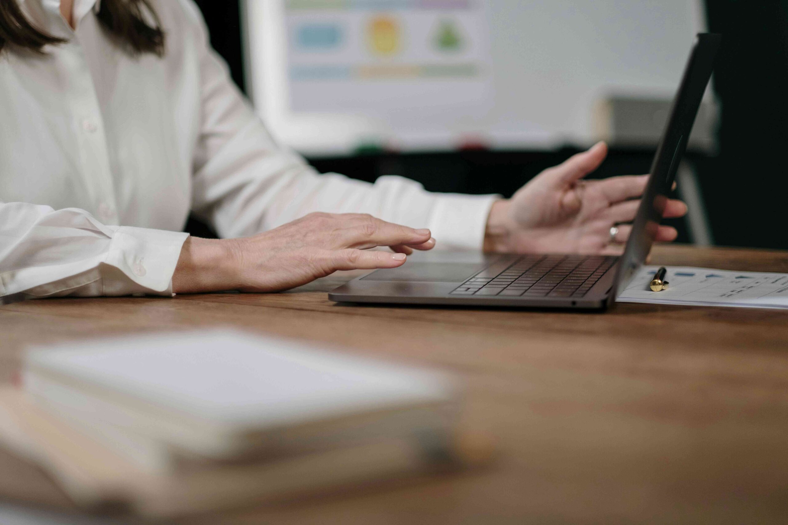 Człowiek ubrany w białą koszulę i czytający informacje na komputerze